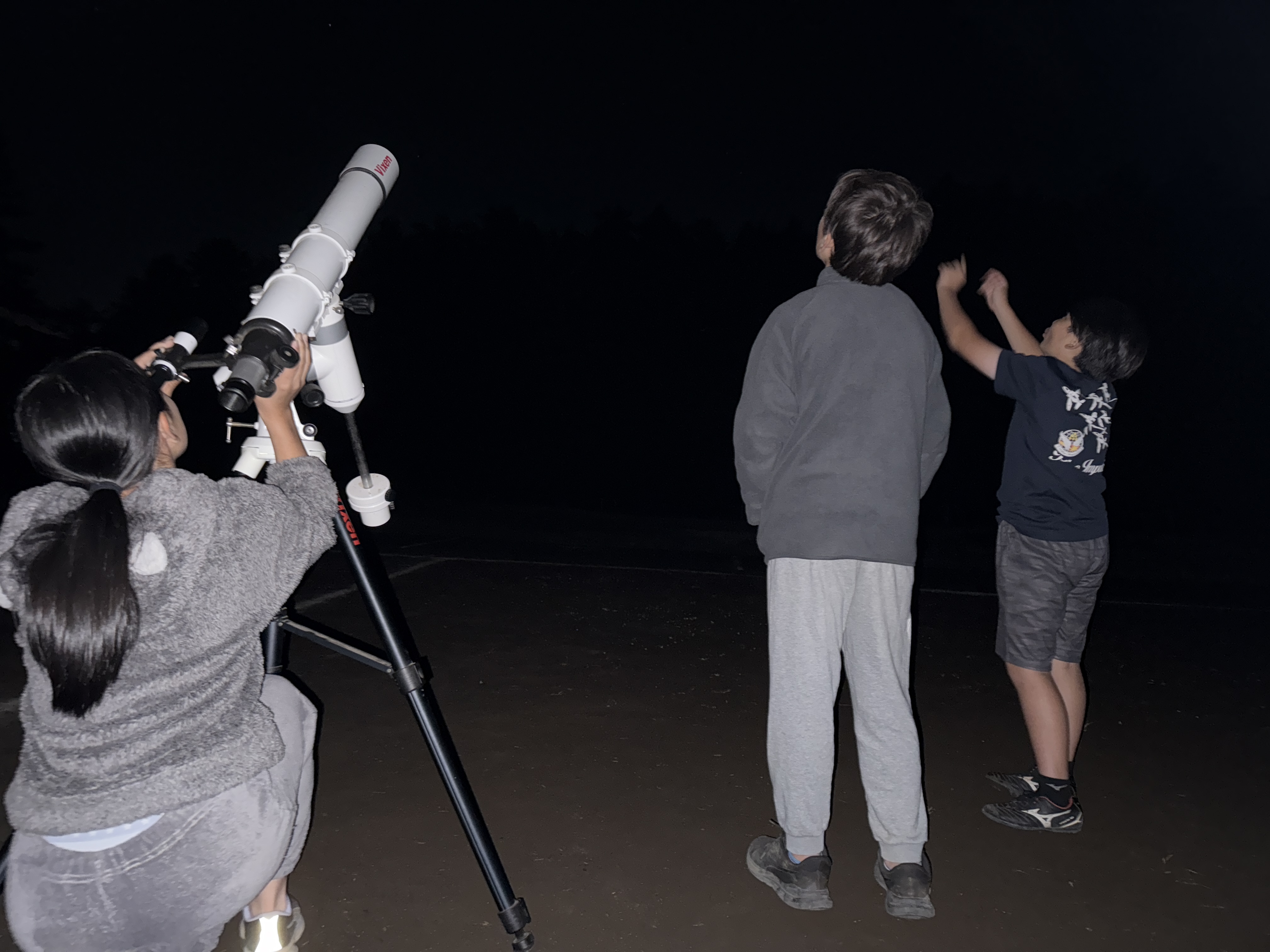 夜間天体観察で星空を見上げる子どもたち
